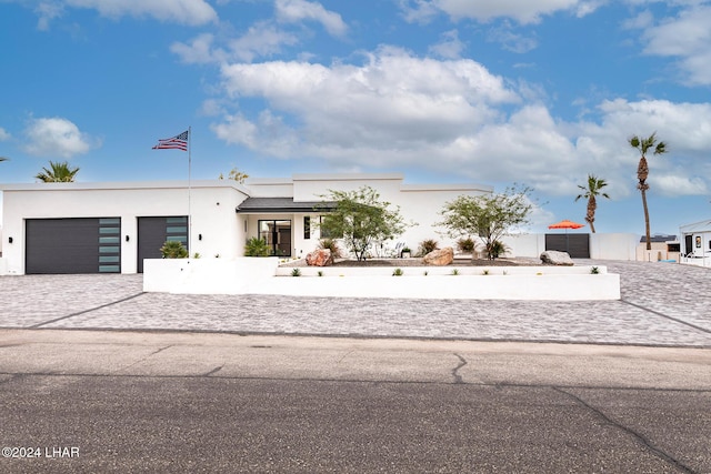 view of front of property with stucco siding, driveway, and an attached garage