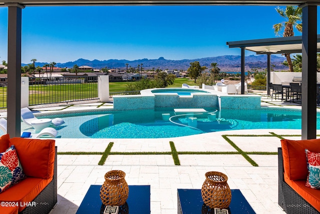 view of pool with a patio, a fenced in pool, an in ground hot tub, outdoor lounge area, and a mountain view