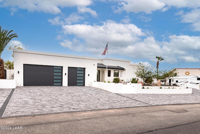 view of front of property with stucco siding, decorative driveway, and an attached garage