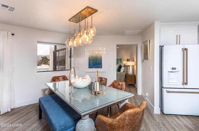 dining area with visible vents, baseboards, and wood finished floors