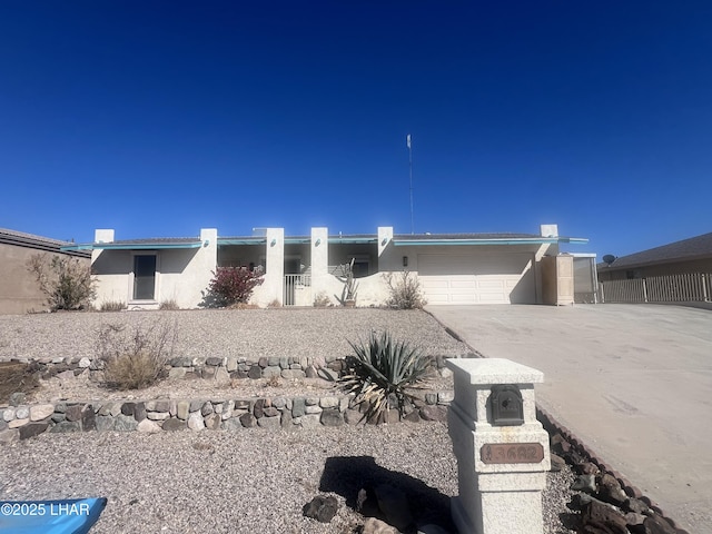 view of front of home with driveway, an attached garage, and stucco siding