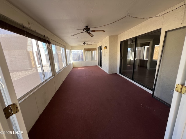 unfurnished sunroom with ceiling fan