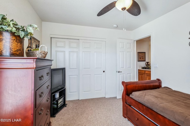 bedroom with light carpet, a closet, and a ceiling fan