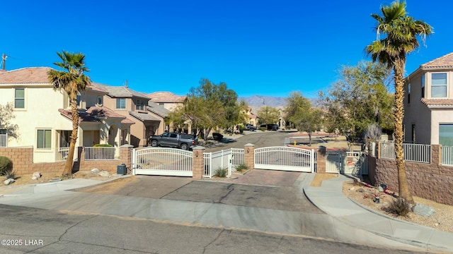 view of street featuring a gate, a residential view, a gated entry, and curbs