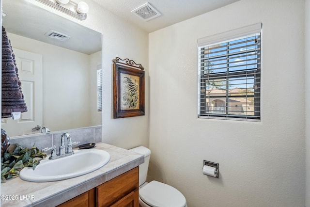 bathroom featuring visible vents, vanity, and toilet