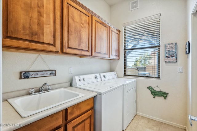 laundry room featuring light tile patterned floors, cabinet space, visible vents, a sink, and separate washer and dryer