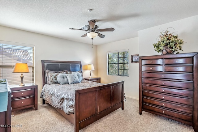 bedroom with baseboards, a textured ceiling, and light colored carpet