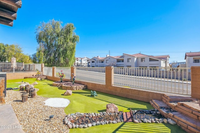 view of yard with a fenced backyard and a residential view