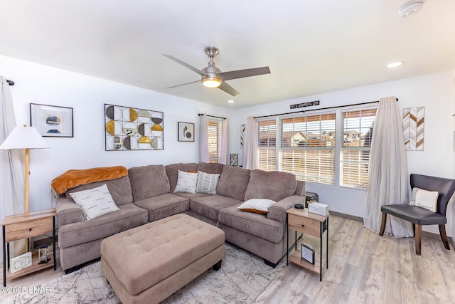 living room featuring ceiling fan and light hardwood / wood-style floors