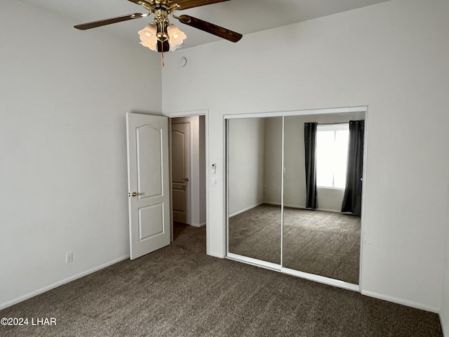 unfurnished bedroom featuring a closet, ceiling fan, and dark colored carpet