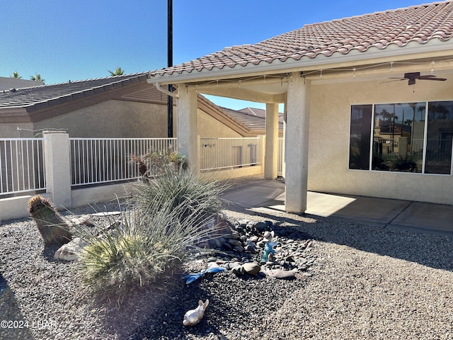 view of side of property featuring a patio and ceiling fan