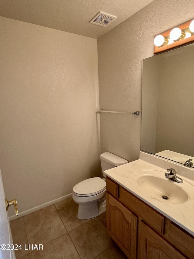 bathroom with vanity, tile patterned floors, a textured ceiling, and toilet