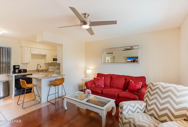 tiled living room featuring ceiling fan and sink