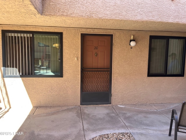 view of exterior entry with stucco siding