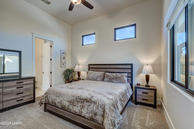 bedroom featuring light carpet, a ceiling fan, and baseboards