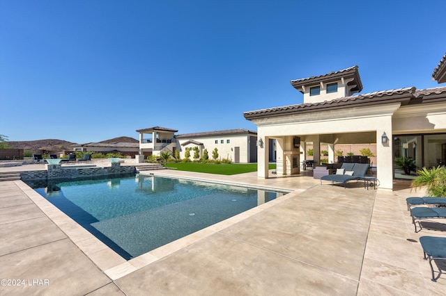 view of pool featuring an outdoor living space with a fireplace, a patio area, and a pool with connected hot tub