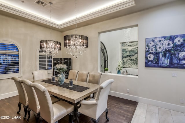 dining area featuring ornamental molding, a tray ceiling, visible vents, and baseboards