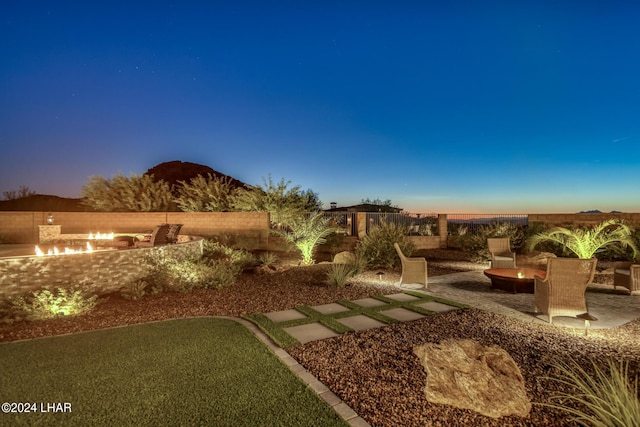 view of yard featuring a patio area, fence, and a fire pit