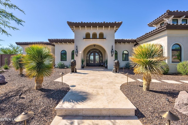 mediterranean / spanish house featuring french doors and stucco siding