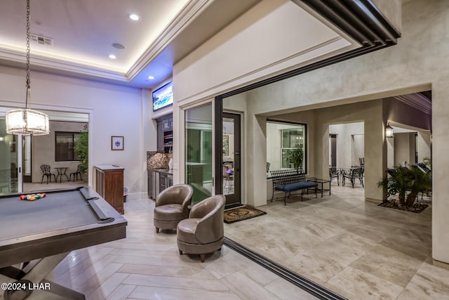 recreation room featuring billiards, visible vents, a raised ceiling, a towering ceiling, and ornamental molding