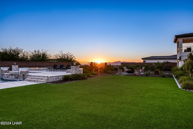 yard at dusk with a patio area and fence