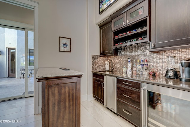 bar with wine cooler, a sink, a healthy amount of sunlight, decorative backsplash, and wet bar