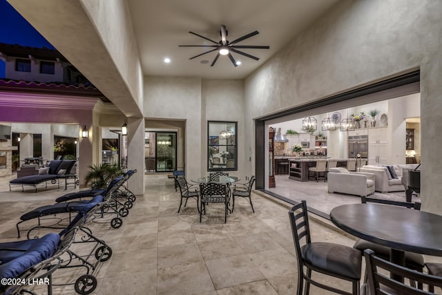 dining space with a towering ceiling, recessed lighting, and ceiling fan with notable chandelier