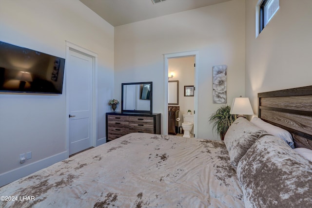 bedroom with visible vents, baseboards, and connected bathroom