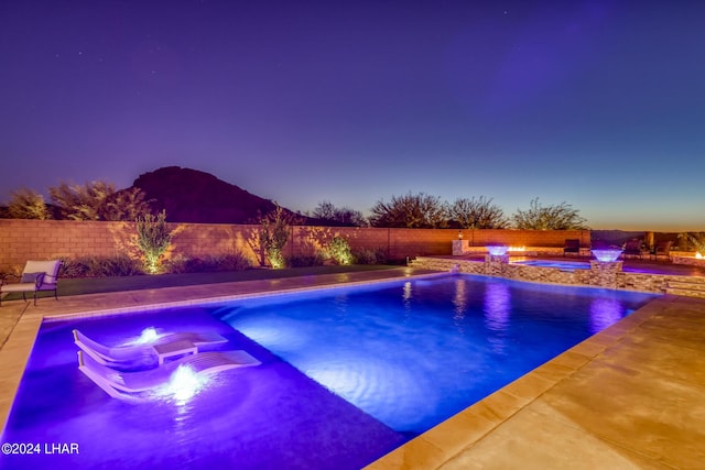 view of pool with a fenced in pool, a patio, a fenced backyard, an in ground hot tub, and a mountain view