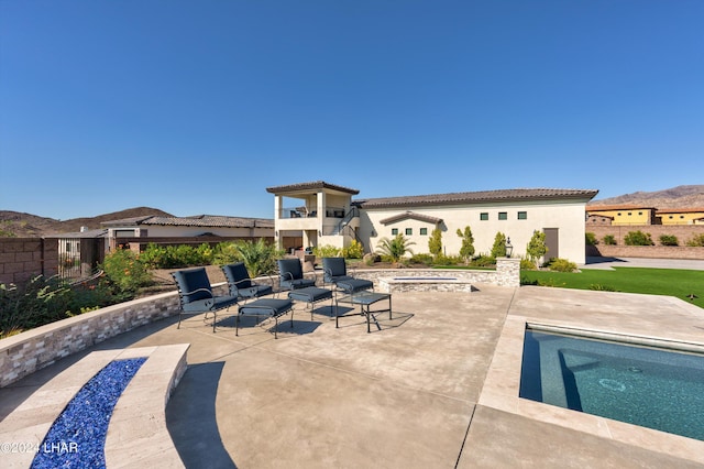 exterior space with a fire pit, a mountain view, and a pool