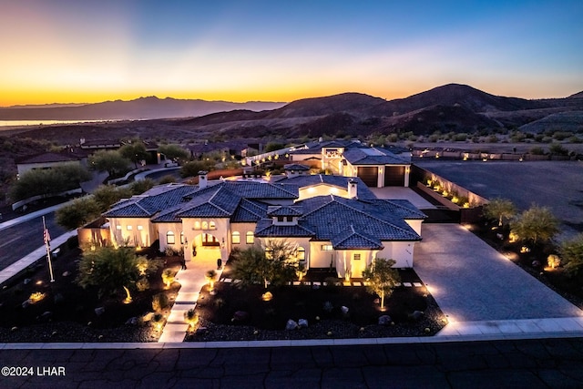 view of front of property with decorative driveway, a mountain view, a tiled roof, and stucco siding