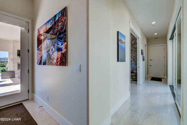 hallway with recessed lighting, baseboards, and light tile patterned flooring