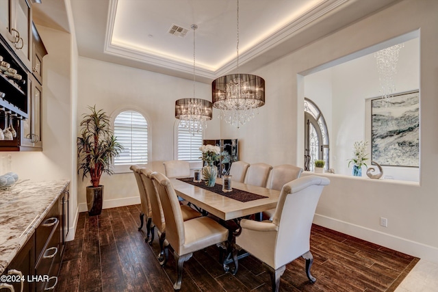 dining area featuring dark wood-type flooring, a raised ceiling, visible vents, and baseboards