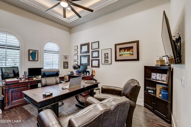 office featuring baseboards, a raised ceiling, ceiling fan, dark wood-style flooring, and crown molding