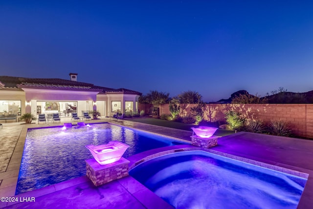 view of pool with a pool with connected hot tub, a patio area, and fence