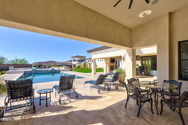 view of patio / terrace with a fenced in pool, outdoor dining space, and a ceiling fan