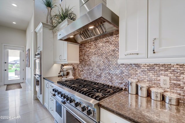 kitchen featuring white cabinetry, appliances with stainless steel finishes, ventilation hood, and decorative backsplash