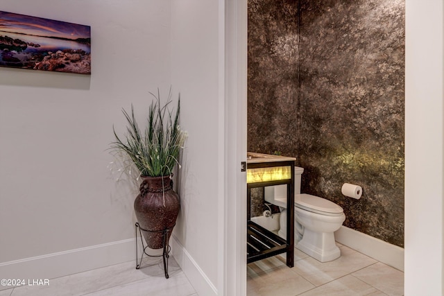 bathroom featuring toilet, baseboards, and tile patterned floors