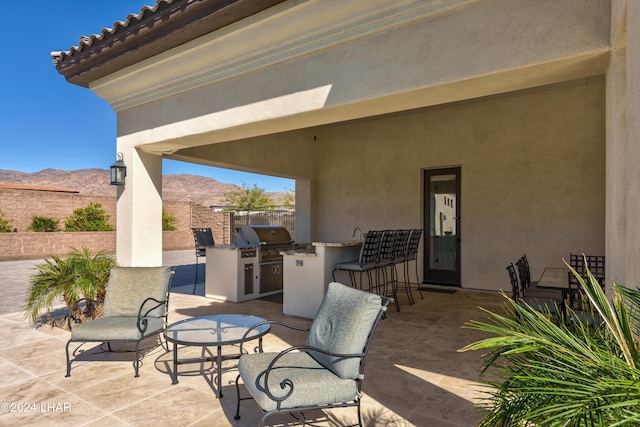 view of patio / terrace featuring area for grilling, fence, and a mountain view