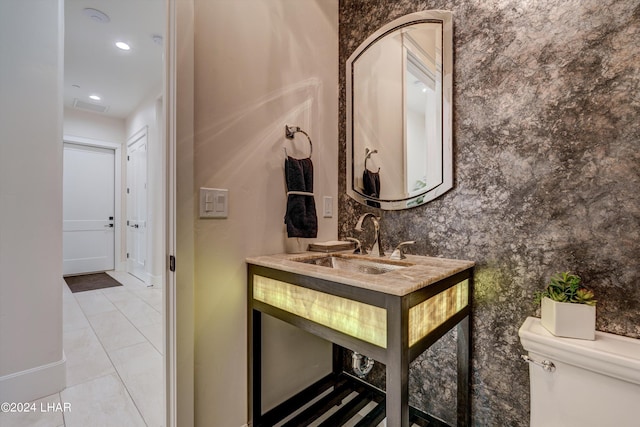 bathroom featuring baseboards, visible vents, toilet, tile patterned floors, and vanity