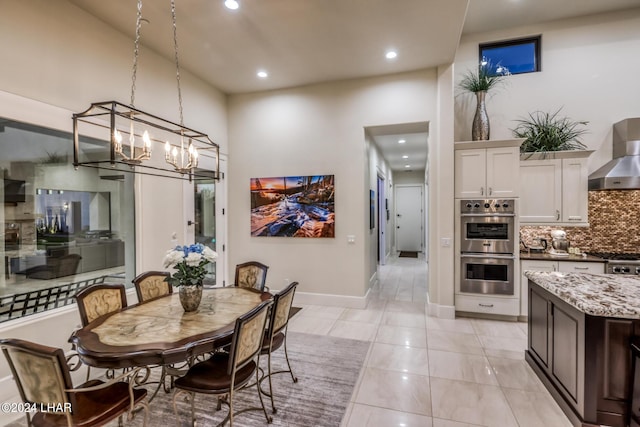 dining room with recessed lighting, baseboards, a high ceiling, and light tile patterned floors