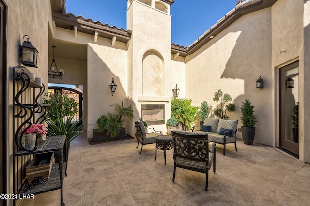 view of patio with an outdoor living space with a fireplace