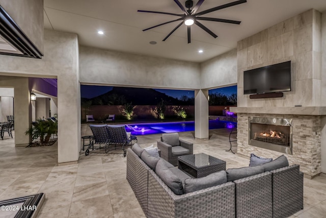 view of patio featuring an outdoor living space with a fireplace and a ceiling fan