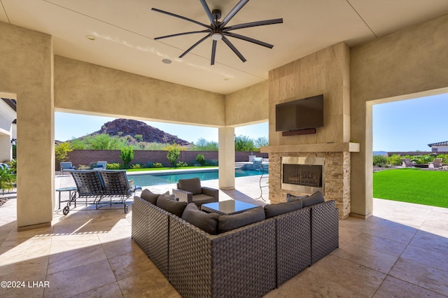 view of patio / terrace with an outdoor living space with a fireplace, a fenced in pool, a ceiling fan, and a fenced backyard