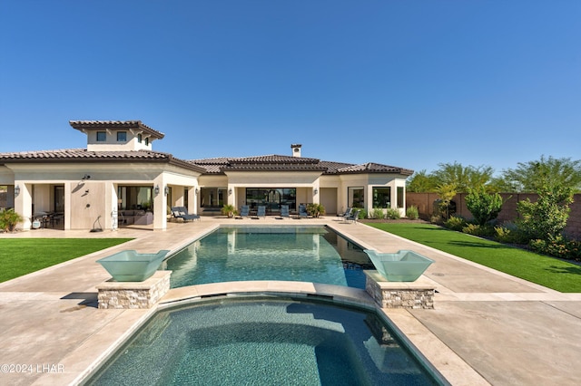 back of property featuring stucco siding, a patio area, a lawn, and fence