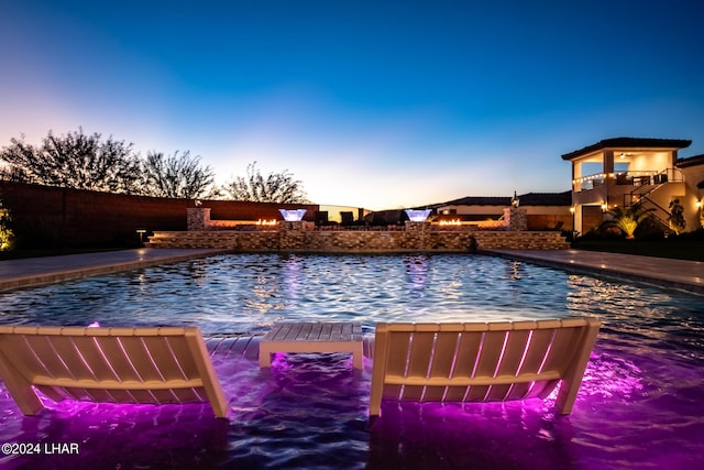 pool at dusk with a fenced in pool