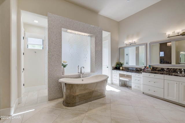 bathroom with a walk in shower, a freestanding tub, and vanity