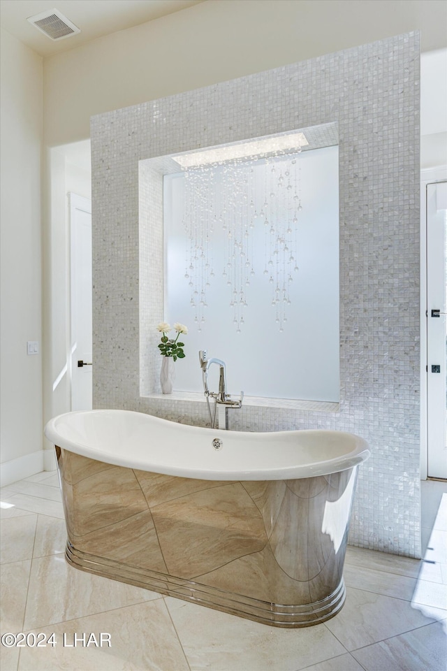 full bath featuring a soaking tub, visible vents, and tile walls