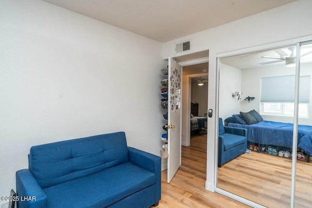 sitting room with ceiling fan, visible vents, and light wood-style flooring