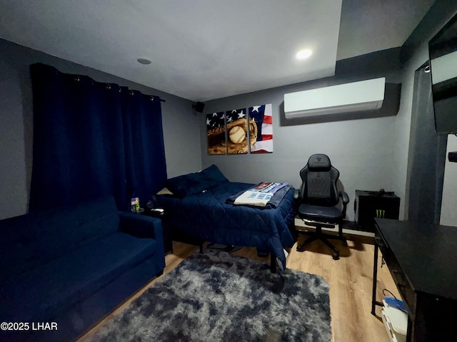 bedroom with a wall unit AC and wood finished floors